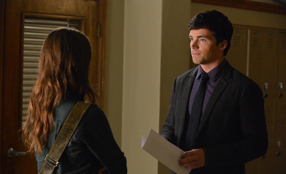 Ezra donne un papier à Spencer